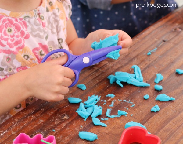 Cutting Play Dough with Plastic Scissors