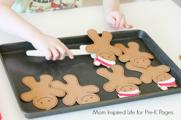scooping gingerbread cutouts off of cookie sheet