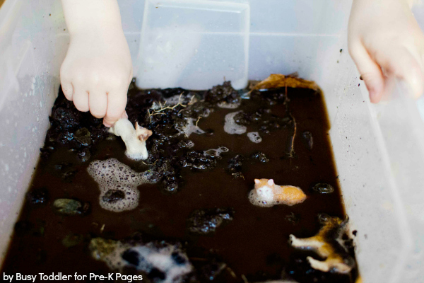 mud and soapy water in a plastic bin with toys